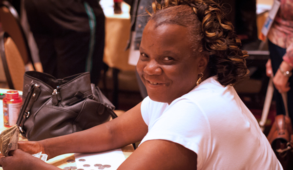 Close up photo of an African-American woman with a disability smiling.
